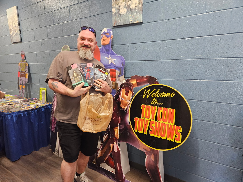 Man standing with several toys in front of Captain America.